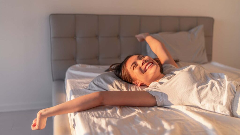 Verbesserung der Schlafqualität: Frau wacht gut ausgeruht auf